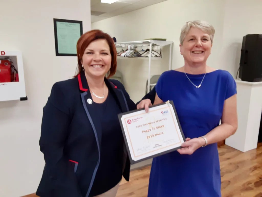 State Representative and Community Action Board Member Donna Oberlander (left) presents Peggy Staab with a certificate recognizing her 2,013 volunteer hours.)

